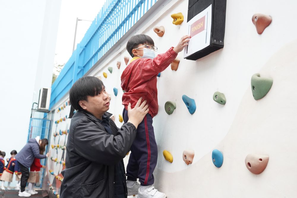 幼稚園學生爬攀石牆，樂在其中。